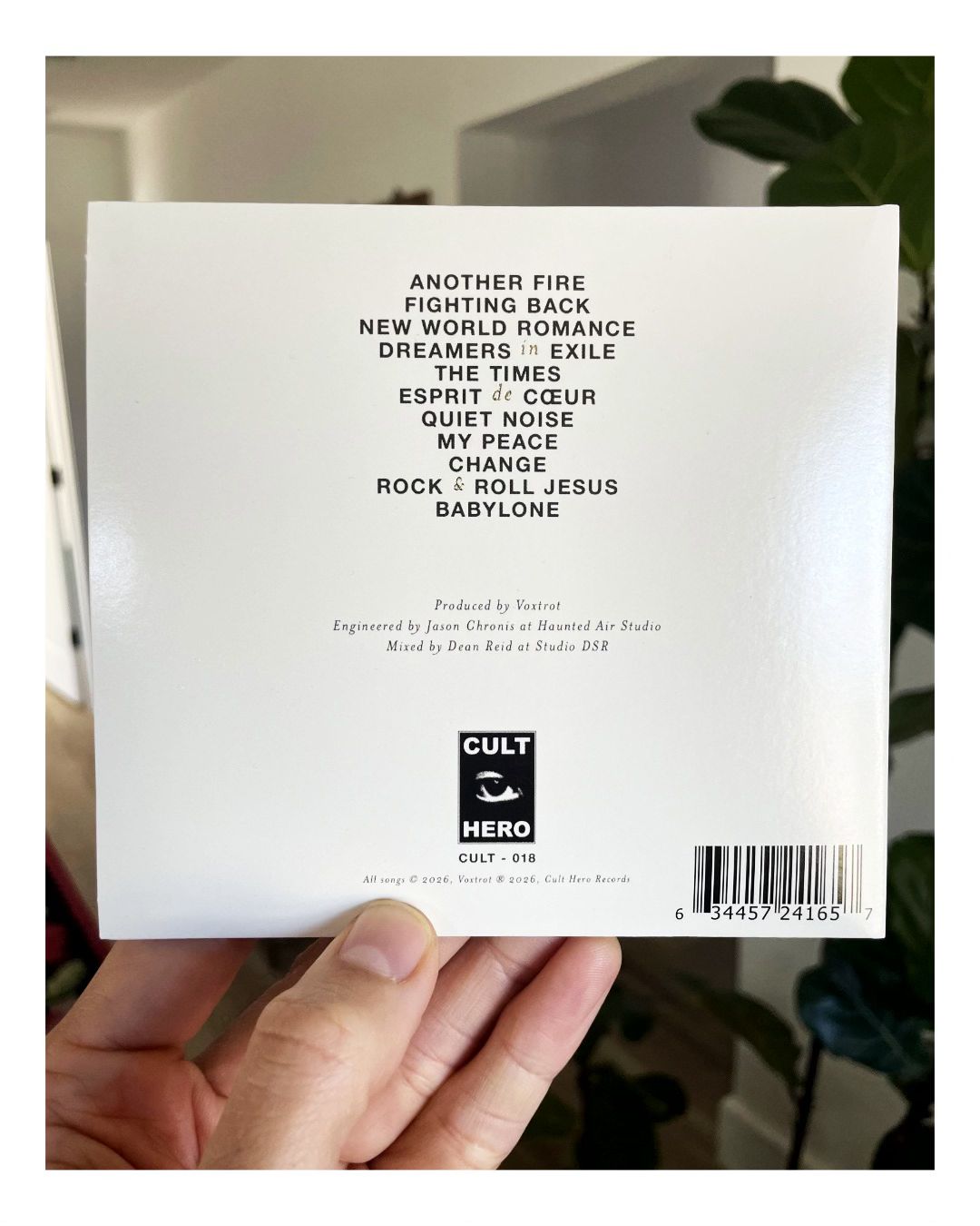 Back cover of a music album held by a hand with visible text and branding.