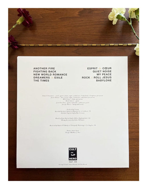 White sheet with black text on a wooden surface with flowers