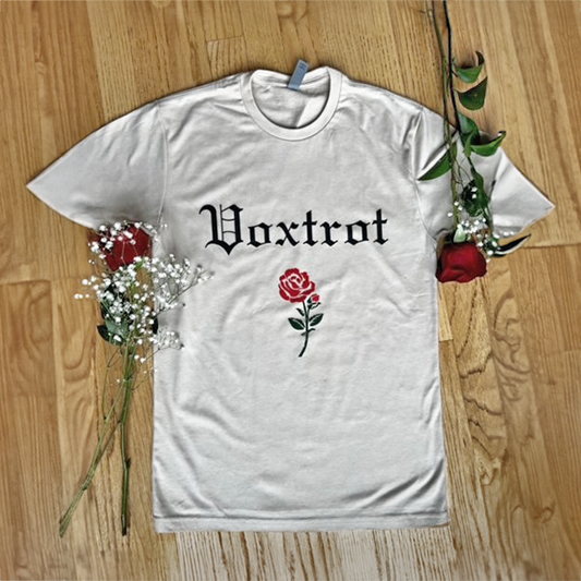 Beige t-shirt with 'Voxtrot' text and red rose design on a wood floor background